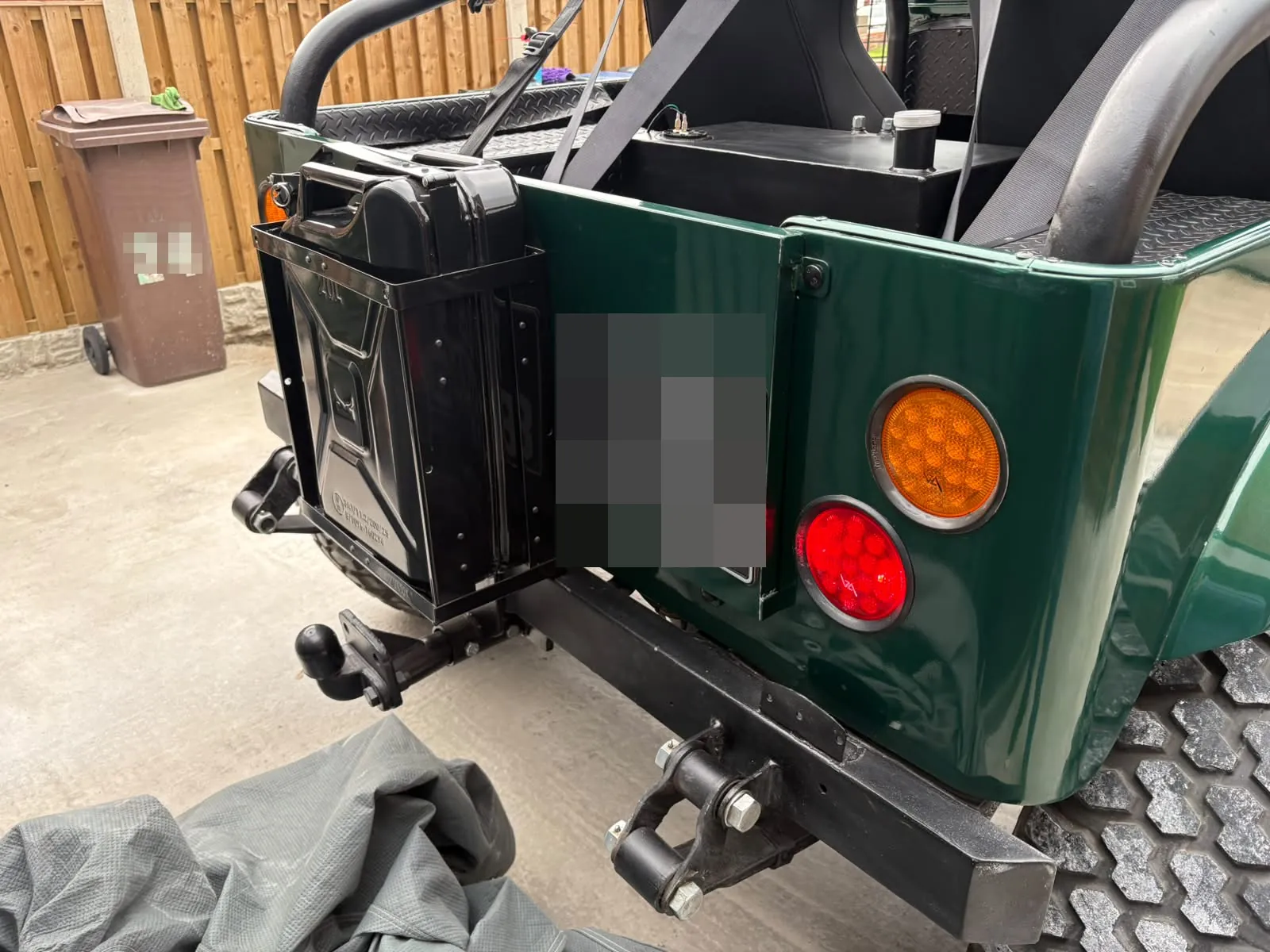 The rear of the finished Jeep, with a jerry can holder, round lights and a tow bar