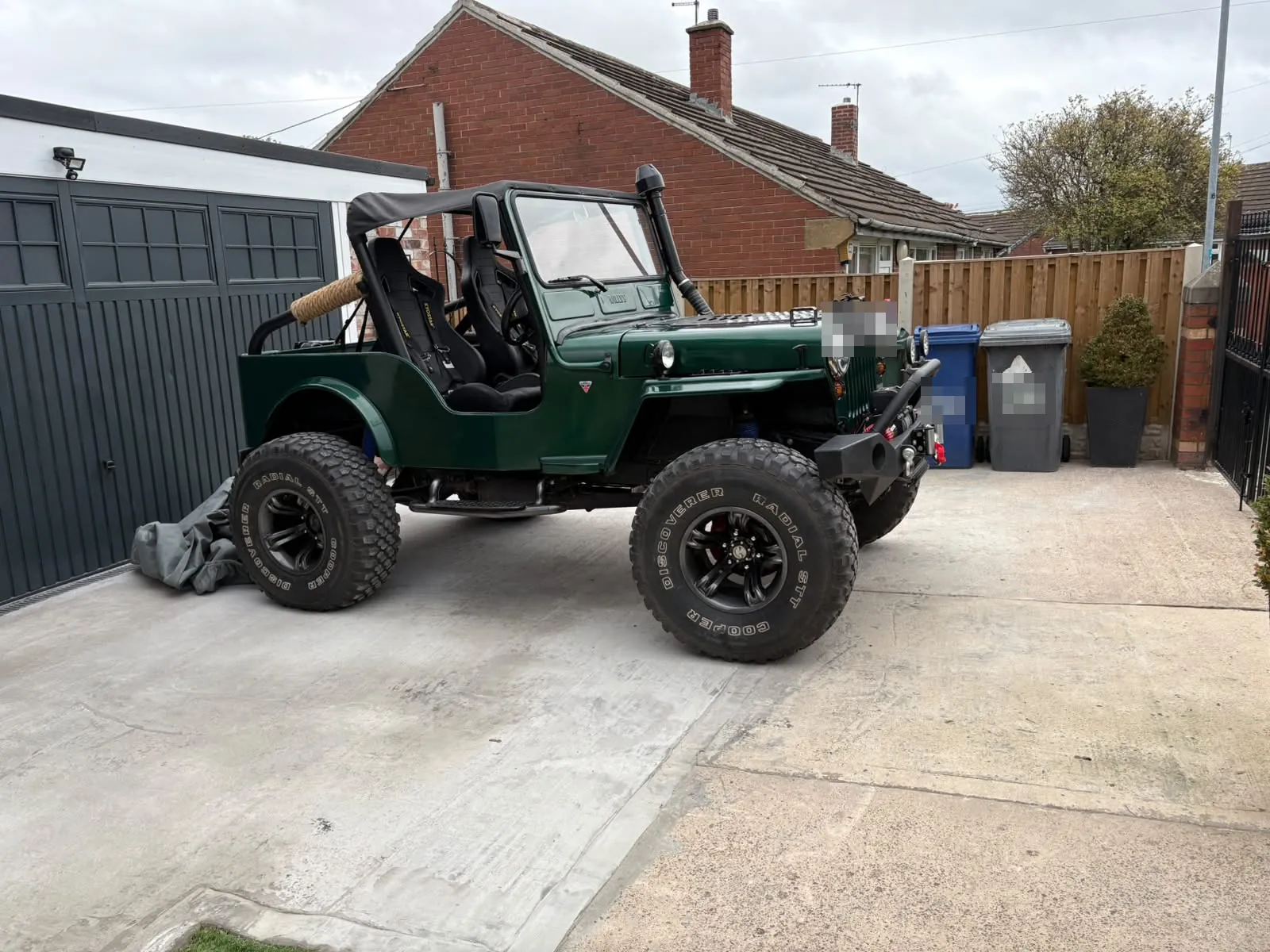 The same Jeep finished in deep green, with a soft top, snorkel, race seats and big off-road tyres