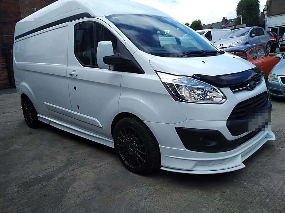 A white Ford Transit van with a full skirt kit fitted