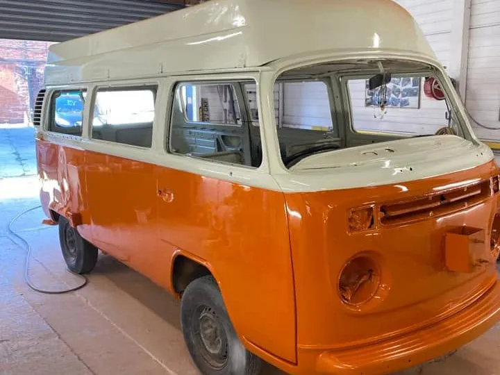 The same VW camper in fresh orange and white paint